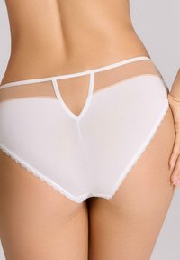Białe majtki z przezroczystymi panelami siateczkowymi, elastycznym paskiem w talii i koronkowym wykończeniem brzegów. Klasyczny kształt fig z niskim stanem.