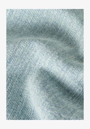 Light blue denim fabric with visible diagonal weave pattern and soft folds creating shadowed texture.