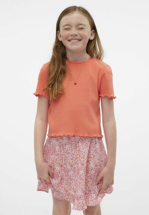 Camiseta de coral con acanalado y bordes ondulados, combinada con una falda floral rosa con dobladillo acampanado. Corte estándar, tejido ligero.
