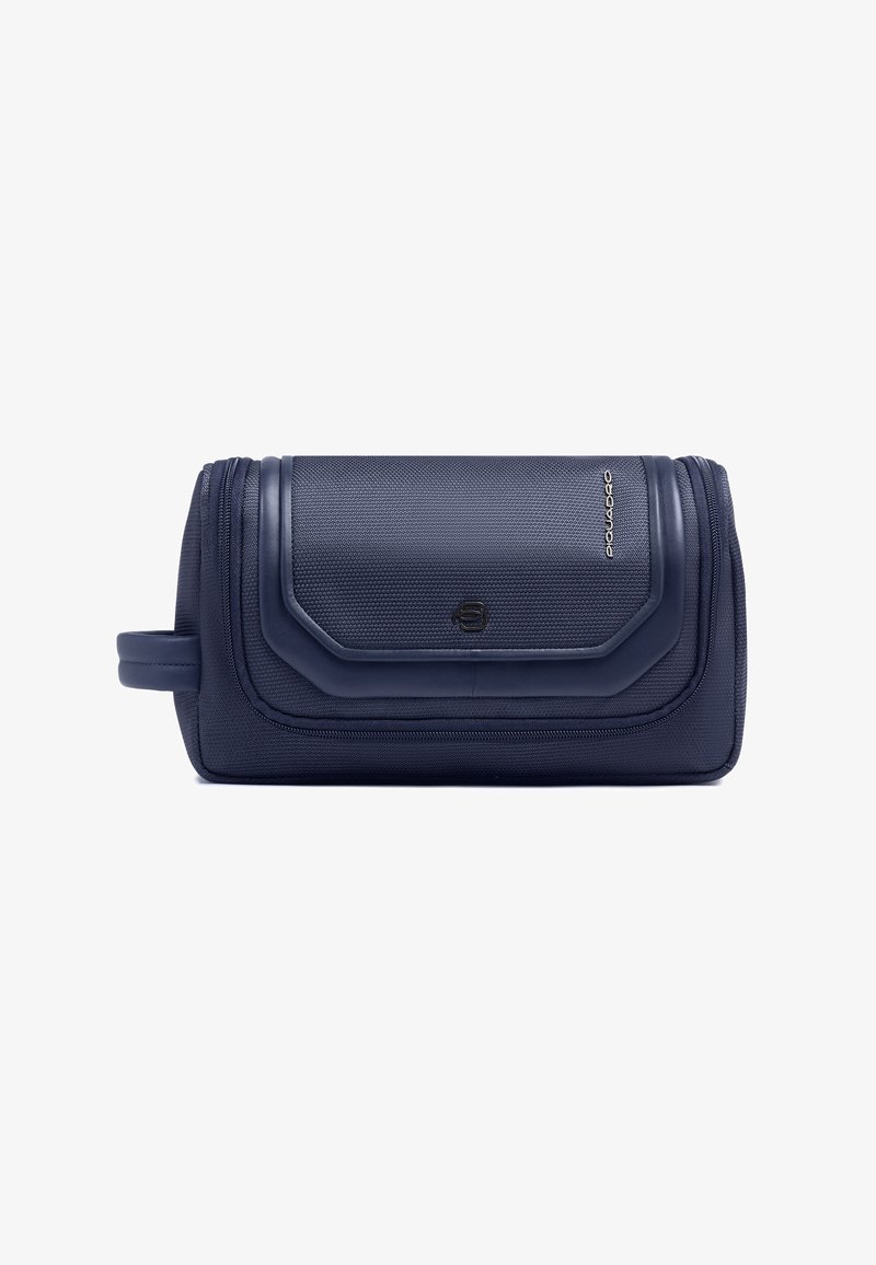 Trousse de toilette texturée bleu marine avec fermeture éclair, coutures décoratives, poignée latérale et petit logo sur le rabat avant.