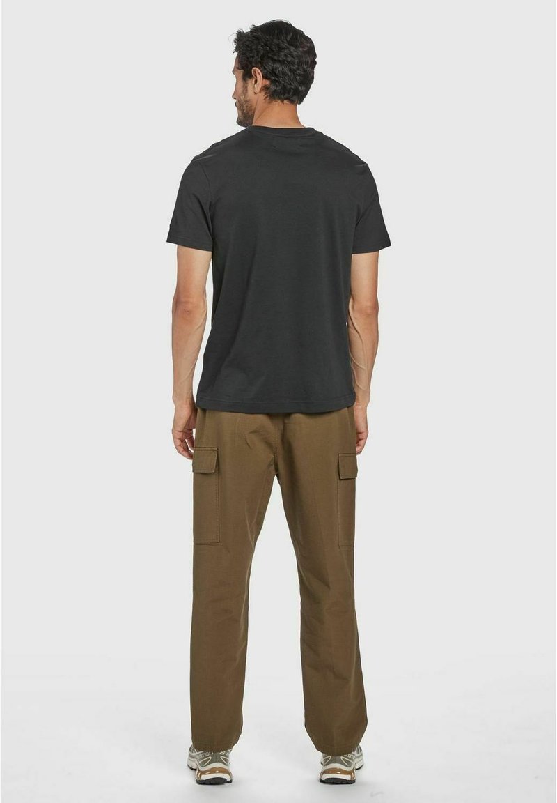 T-shirt nera in cotone con collo a giro e maniche corte, abbinata a pantaloni cargo khaki a vestibilità ampia con tasche laterali.