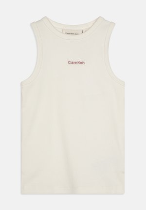 Kreemist, varrukateta tanktipluusist ribbitatud tekstuuriga ning esiküljel väike punane "Calvin Klein" logo. Tavaline, lõdva disainiga, ilma lisamustriteta.