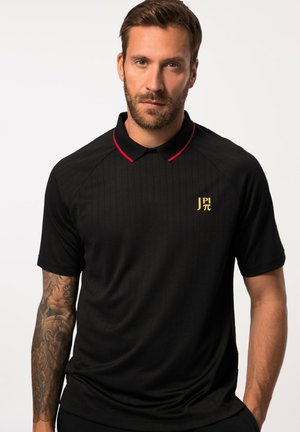 Sort polo skjorte med røde detaljer på kraven. Har lodrette striber og et gyldent logo på brystet. Blødt, glat stof. Korte ærmer.