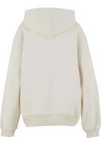Felpa color crema con una vestibilità ampia, dotata di un grande cappuccio, polsini e orlo a costine, realizzata in un materiale morbido con texture minimale.