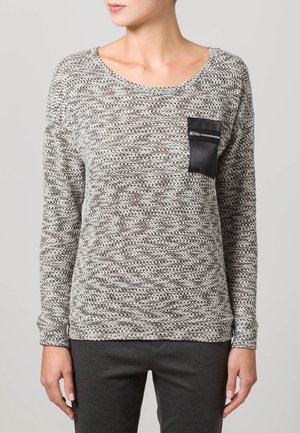 Harso neulepaita harmaana, jossa on tekstuuripainatus, pyöreä pääntie ja musta vetoketjullinen tasku vasemmalla etupuolella. Pitkät hihat.