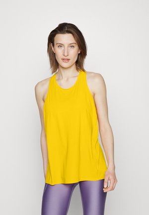 Top atlético amarelo sem mangas feito de tecido leve, com um corte descontraído e decote redondo, combinado com leggings roxas.