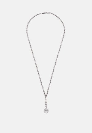 Srebrna ružarija sa perlicama i okruglim privjeskom s križem u sredini na bijeloj pozadini.