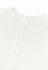 Balts ribots adīts tops ar apaļu kakla izgriezumu un viļņotu pogu pogu ar sešām pogām aizdarei. Mīksta tekstūra, bezādītes dizains.