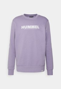 Fialová mikina vyrobená z měkké tkaniny, s kulatým výstřihem, dlouhými rukávy a výrazným bílým logem "HUMMEL" na hrudi.