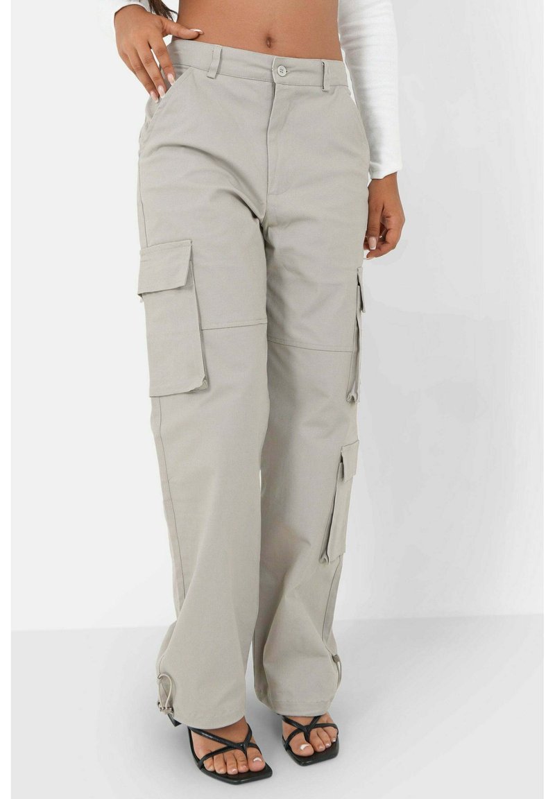 Cargo broek in een lichtbeige kleur, gemaakt van een duurzaam materiaal. Kenmerkt zich door brede pijpen, meerdere zijzakken en een relaxte pasvorm met hardware-accenten.