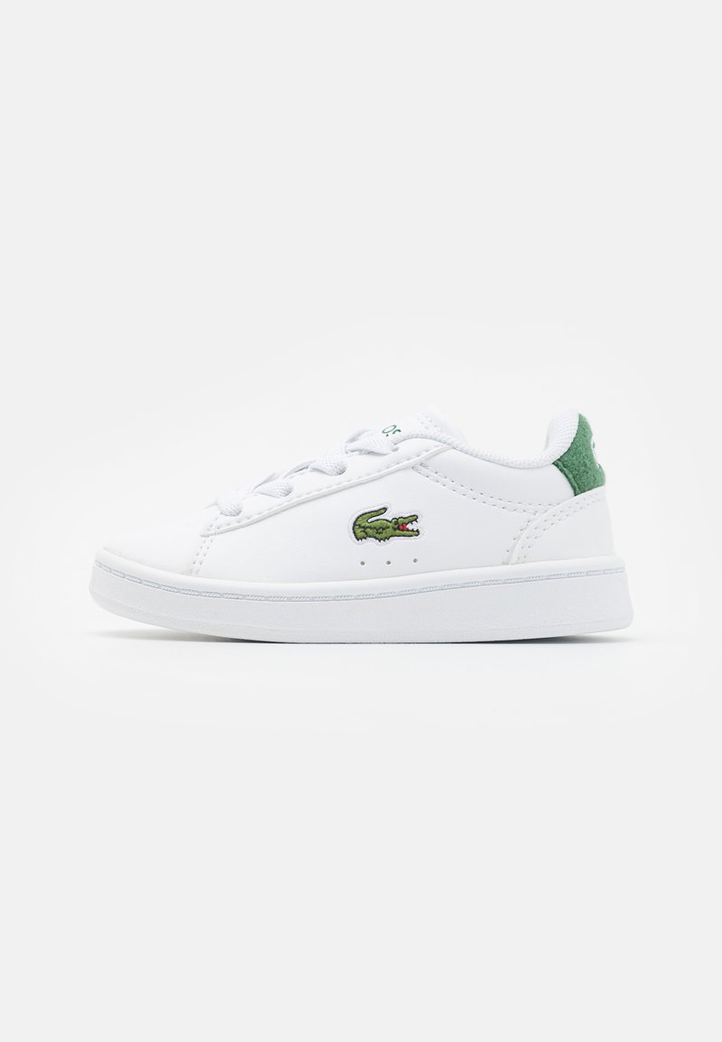 Zapatillas bajas blancas hechas de material sintético, con detalles en verde en el talón y un logo bordado de cocodrilo verde en el lateral.