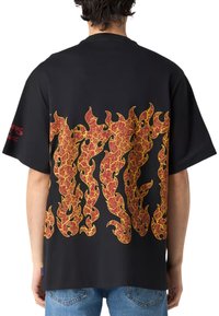 Sort t-shirt med et stort grafisk tryk af røde og gule flammer på ryggen. Designet med korte ærmer og en afslappet pasform.
