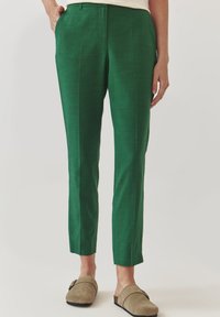 Groene op maat gemaakte broek van lichtgewicht materiaal met een gladde textuur. Heeft een klassieke pasvorm, zijzakken en een vlakke voorkant.