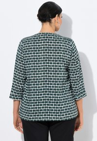 Donkergroen blouse met een lichtgroen en wit ruitpatroon, driekwart mouwen, ronde hals en een relaxte pasvorm.