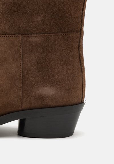 Braunes Wildleder-Ankle-Boot mit strukturiertem Finish, ausgestattet mit einem schwarzen, gestapelten Absatz und genähten Paneeldetails.