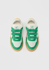 Valged tossud roheliste seemisnahast detailide, võrgust detailide ja kummist tallaga. Omavad kolme rohelist takjakinnitust ja väike logo keelega.