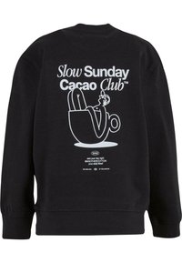 Felpa nera con una stampa grafica bianca sulla schiena, che raffigura una figura che si rilassa in una tazza. Il testo recita "Slow Sunday Cacao Club."