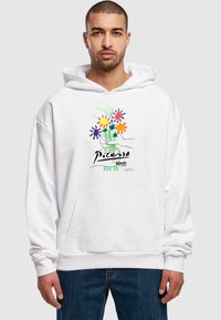 Felpa bianca con tasca frontale e maniche lunghe, con un design floreale colorato e il testo "Picasso" stampato sul petto.