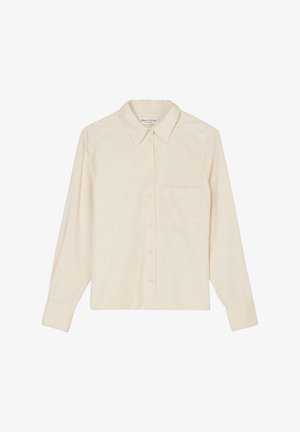 Vaaleanbeige corduroy-paita, jossa on pitkät hihat, kaulus ja yksi rintatasku. Edessä on napitettava kiinnitys ja kankaan pinta on teksturoitu.