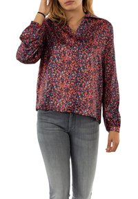 Multicolored blouse with a vibrant pattern of red, blue, and pink, featuring a collar and long sleeves, made from lightweight fabric.