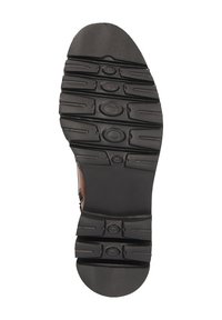 Suola in gomma nera con grip testurizzato, caratterizzata da motivi circolari. Mostra un design del battistrada dettagliato per aderenza e stabilità.