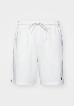 Fehér pamut rövidnadrág, rugalmas derékkal, zsinórral és oldalsó hasítékokkal. A bal szegélyen található egy kis fekete logó.