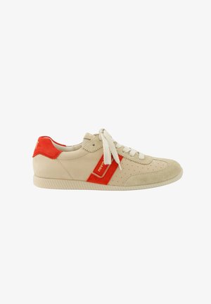 Beige and red low-top sneaker with suede accents, perforated detailing, white laces, and a rubber sole, shown from the side.