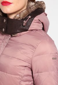 Różowa kurtka ocieplana z brązowym kołnierzem z syntetycznej skóry z futrzanym wykończeniem, srebrnymi akcentami i teksturowanym materiałem, odpowiednia na zimne dni.