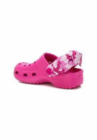 Zuecos de color rosa brillante con un diseño perforado, correa ajustable con un patrón de panal y suela texturizada para agarre y comodidad.
