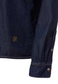 Donkerblauwe denim shirt met een gouden merkembleem en zilveren knopen op de manchetten. Inclusief contrasterende stikdetails.