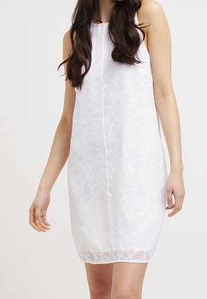 Robe blanche sans manches avec un motif floral géométrique, présentant une silhouette droite et un tissu doux et texturé.