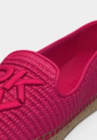 Φωτεινό ροζ πλεκτό εσπαντρίγια με πλεγμένη σόλα από γιούτα και ανάγλυφη κεντημένη λογότυπο στο μπροστινό μέρος της πάνω πλευράς.