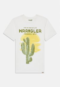 Hvit bomulls T-skjorte med grafikk av en grønn kaktus på gul bakgrunn og teksten "Wrangler Grunnlagt 1947" i fet grønne bokstaver.