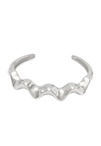 Bracciale in argento con un design scultoreo ondulato e estremità aperte, che riflette la luce su uno sfondo bianco.