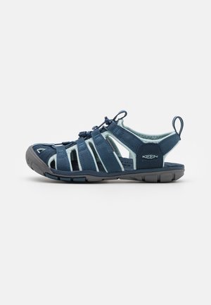 Outdoor blaue und graue Sandale mit geschlossener Zehenpartie, verstellbaren Riemen, Gummisohle und Markenlogo am Fersenriemen.