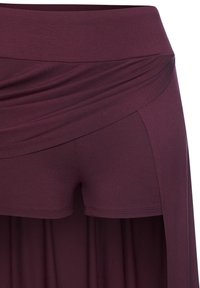 High-waisted plum purple layered skirt with attached fitted shorts underneath, made of soft, stretchy fabric.