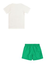 T-shirt bianca in cotone con scollo rotondo e maniche corte, abbinata a pantaloni da bagno verdi con vita elastica e texture liscia.