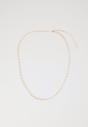 Delicate gouden ketting met ovale en horizontale balkschakels, plat gelegd op een witte achtergrond met een verstelbare verlengkettinkje.