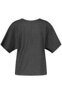 Camiseta negra de gran tamaño con mangas cortas, escote redondeado y un detalle de costura en el centro de la parte posterior. Fabricada en una tela suave y ligera.