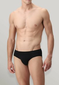 Slip neri da uomo con una superficie liscia e una vita elastica, caratterizzati da un design minimalista senza fantasie o parti metalliche a vista.