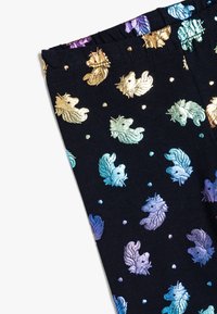 Leggings neri con un pattern di unicorni iridescenti e colorati, arricchiti da accenti dorati, viola e verde acqua, su uno sfondo scuro uniforme.
