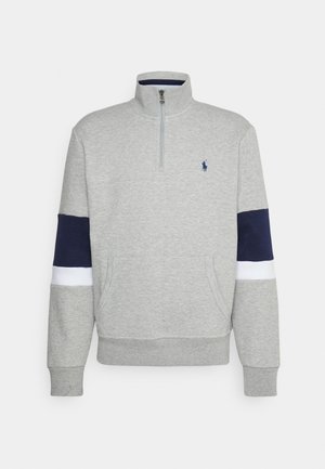 Hellgrauer Sweatshirt mit Viertel-Reißverschluss, mit marineblauen und weißen Streifen an den Ärmeln, Kängurutasche vorne und kleinem besticktem marineblauen Logo auf der Brust.