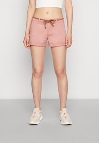 Light pink cotton shorts with rolled hems, featuring a brown braided drawstring at the waist. Worn with neutral athletic sneakers.