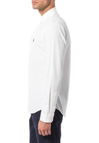 Weißes Langarmhemd mit Button-Down-Kragen, das ein kleines marineblaues Logo auf der Brust und knöpfbare Manschetten aufweist. Glatte Stoffstruktur.