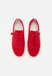 Rote Wildleder-Sneaker mit flachen Schnürsenkeln, seitlichen Reißverschlüssen und Gummisohlen. Sie besitzen ein strukturierter Obermaterial und ein einfarbiges Design.