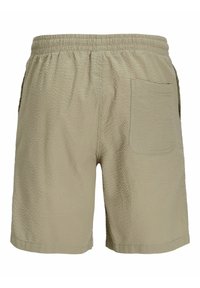 Beigās šortos ir teksturēta auduma, elastīga jostasvieta un viena aizmugurējā kabata. Dizaina iezīmes ietver brīvu piegriezumu un gludu apakšmalu.