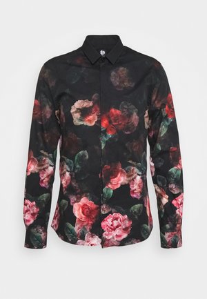Camisa negra de manga larga con un patrón floral de rosas rojas y rosas en tonos rosa junto con hojas verdes, confeccionada en una tela suave con cuello abotonado.