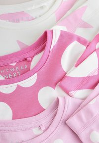 Trois t-shirts à manches courtes superposés : un blanc avec des étoiles roses, deux roses avec des pois blancs, présentant des encolures côtelées et un tissu doux.
