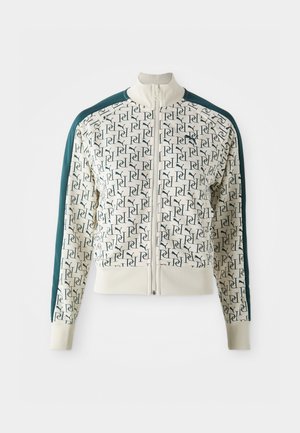 Jacket featuring a cream body with a repeating green logo pattern, contrasting dark green sleeves, a high collar, and a front zipper.