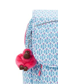 Zaino con motivo blu che presenta un morbido portachiavi a forma di scimmia rosa attaccato a una cerniera. Il motivo include accenti blu chiaro e rosa.